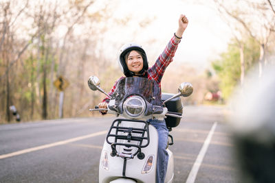 Portrait of smiling young woman walking on road