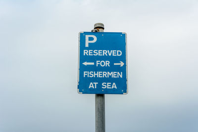 Low angle view of sign against sky