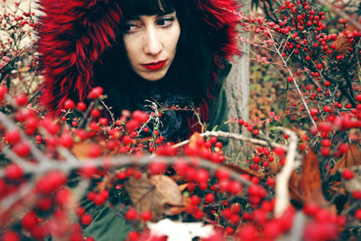 Woman wearing fur coat amidst red berries