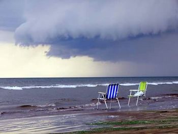 Scenic view of beach against cloudy sky