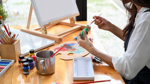 Woman painting on canvas at home