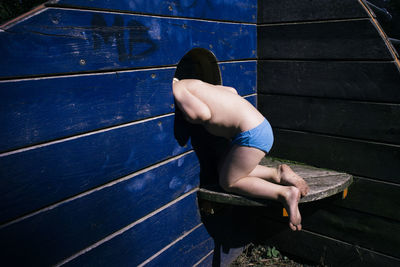 Child peeping through hole in the wall