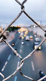 Close-up of snow on fence against sky