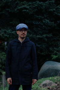 Portrait of man standing against waterfall