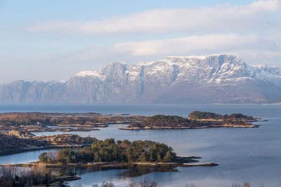 Scenic view of river and mountains against cloudy sky