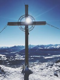 Street light on snow covered landscape against sky