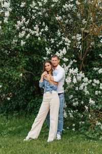 Loving happy young couple embraces in the park of blooming lilac in spring person