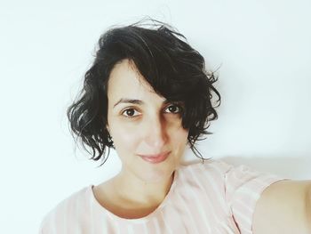 Portrait of young woman against white background