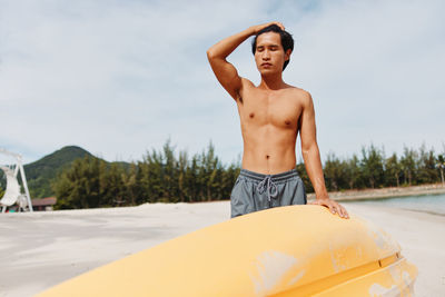 Portrait of shirtless man standing in boat