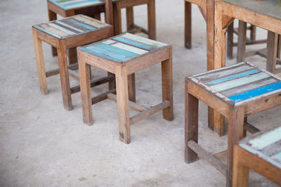 High angle view of wooden stools by tables at restaurant