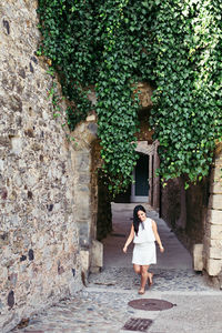 High angle view of young woman walking on footpath amidst building