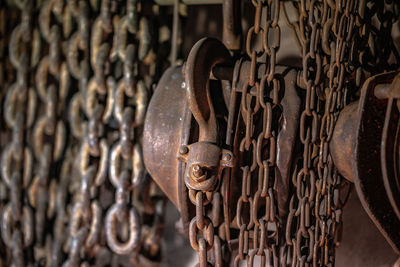 Close-up of rusty chain hanging on metal gate