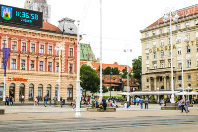 Group of people on road against buildings in city