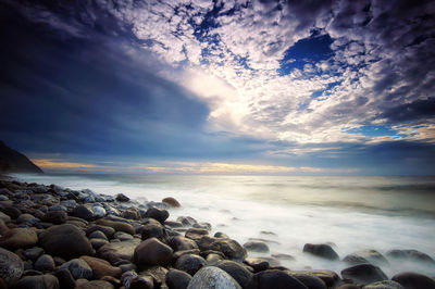 Rocks on beach against sky