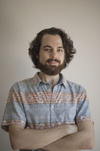 Portrait of young man standing against white background