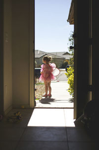 Girl wearing fairy costume seen from doorway
