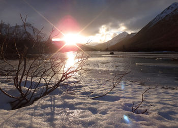 Scenic view of frozen lake against sky during sunset