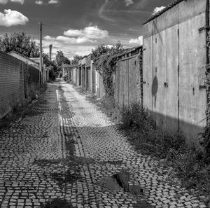 Empty footpath amidst buildings in city