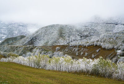 Scenic view of snow covered land against sky