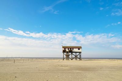 Lifeguard hut on beach against sky