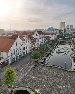 High angle view of buildings by river against sky