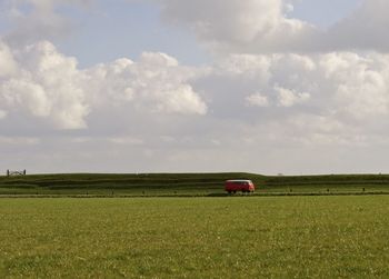 Tractor on agricultural field against sky