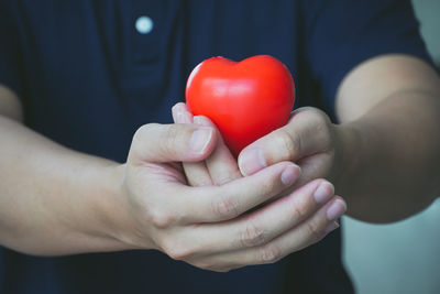 Close-up of hand holding red heart shape