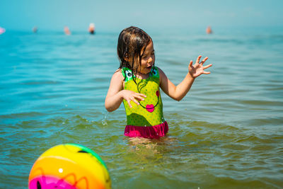 Girl playing with ball at beach