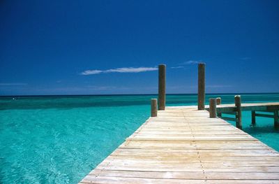 Pier over sea against blue sky