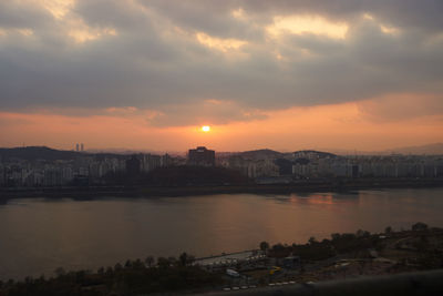 View of city at waterfront during sunset