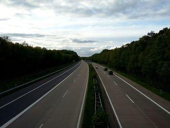 Country road against cloudy sky
