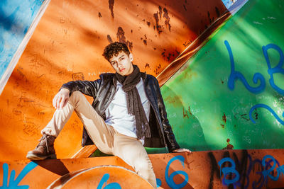 Young male model posing on metal sculpture