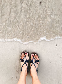 Low section of man standing on beach