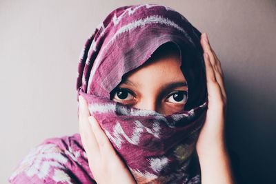 Portrait of beautiful young woman against white background