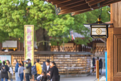 People on illuminated street light against building