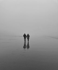 Couple on beach against sky
