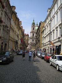 People walking on road amidst buildings in city