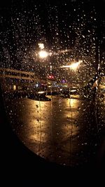 Close-up of wet illuminated car at night