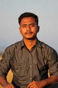 Portrait of young man standing against wall