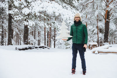 Portrait of smiling man standing in snow