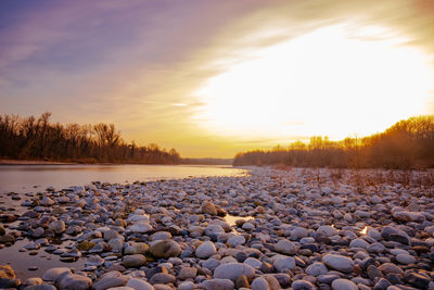 Scenic view of snow covered land against sky during sunset