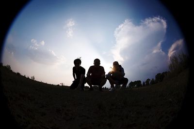 Low angle view of men standing against sky