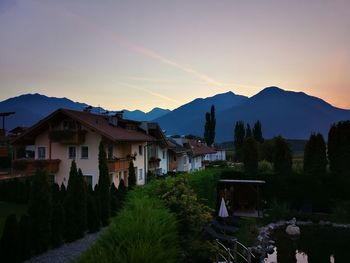 Houses and buildings against sky at sunset