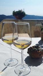 Wine glass on table against sky