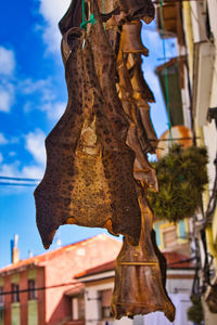 Low angle view of cross hanging on building against sky