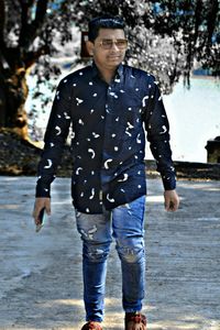 Full length portrait of mid adult man standing on water