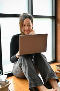Businesswoman using laptop while sitting on table