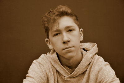 Portrait of teenage boy against brown background