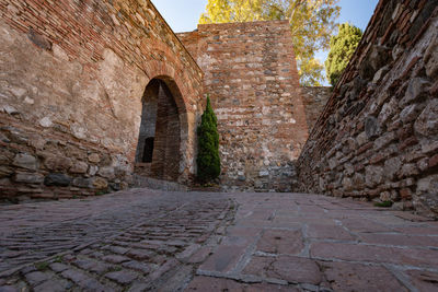 Footpath amidst old building against sky