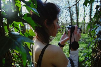 Rear view of woman photographing through smart phone